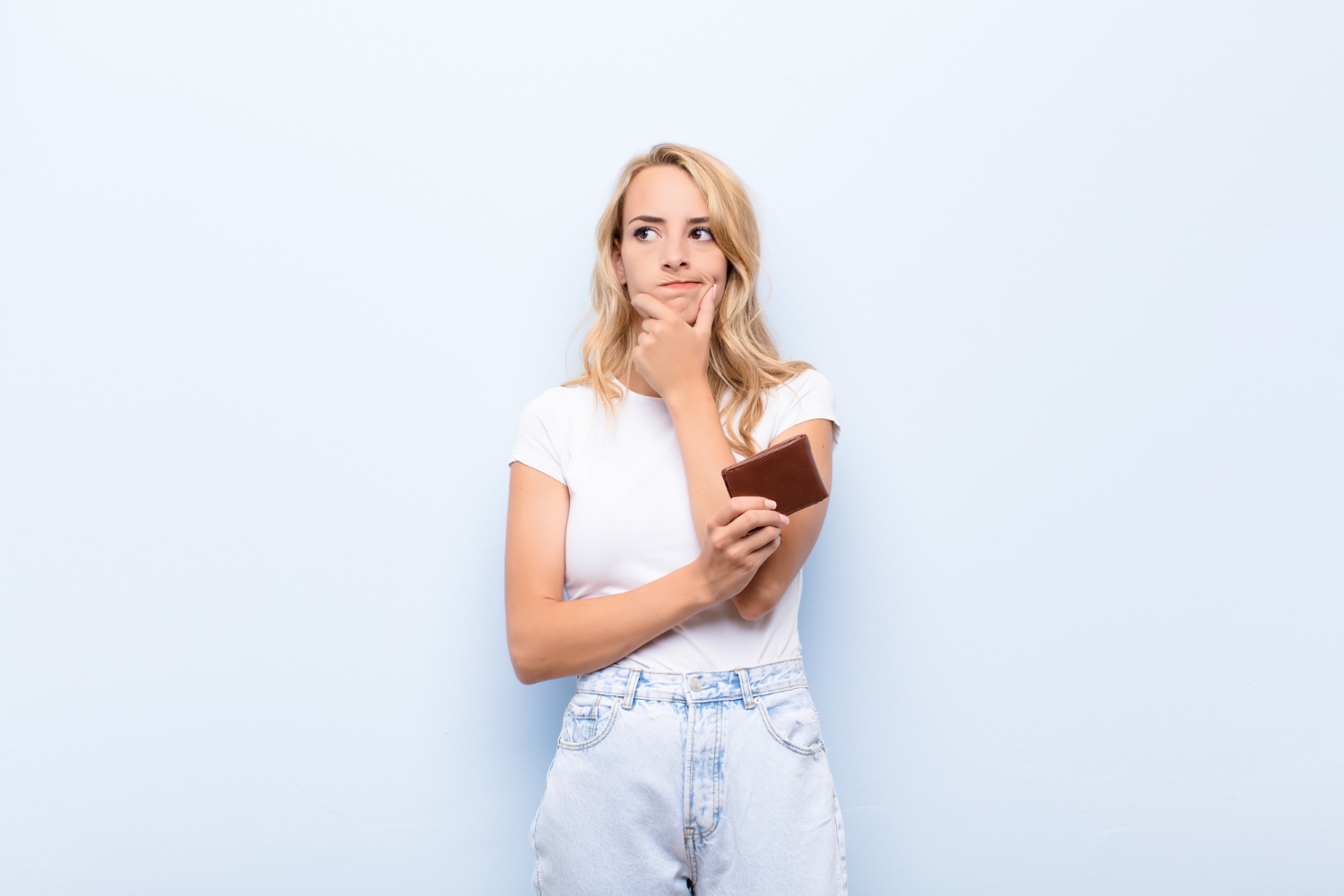 young-blonde-woman-thinking-feeling-doubtful-and-confused-with-different-options-wondering-which-decision-to-make-holding-a-wallet 